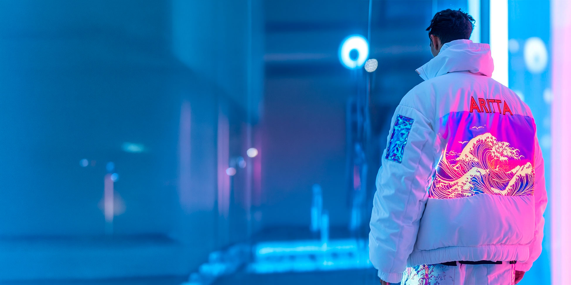 Model wearing the white ARITTA wave jacket in a blue and pink neon setting